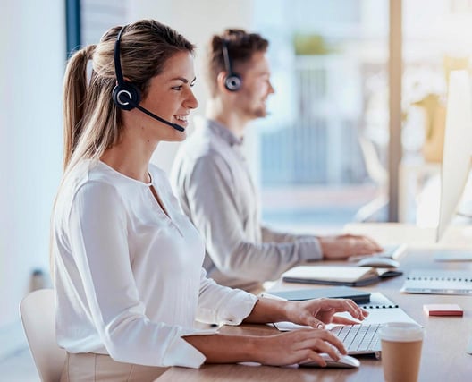 Eine Frau und ein Mann bei der Arbeit im Callcenter 