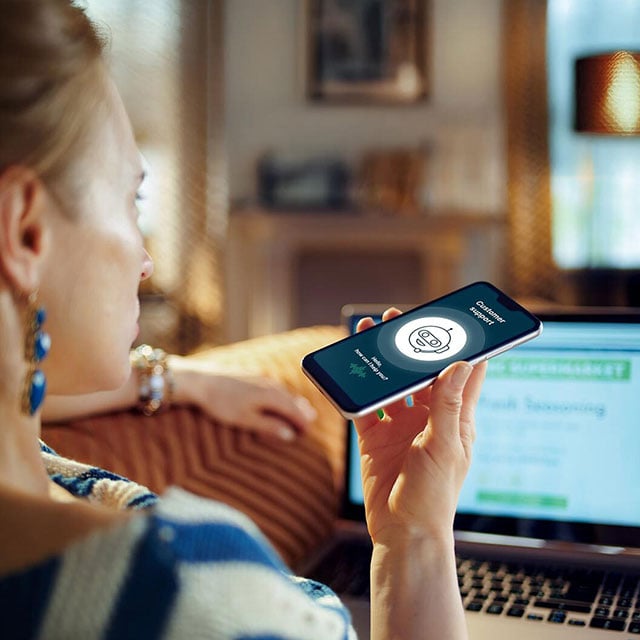 Women talking to a customer service voicebot on her smartphone