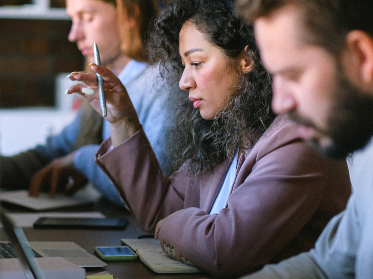 three employees looking at screens