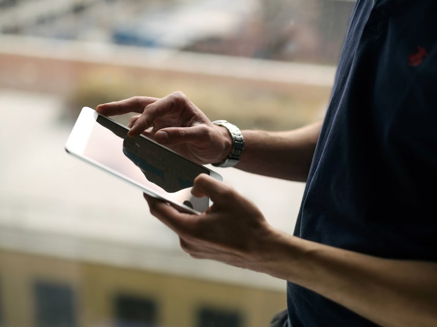 Seitenansicht einer Person, die ein Tablet bedient  