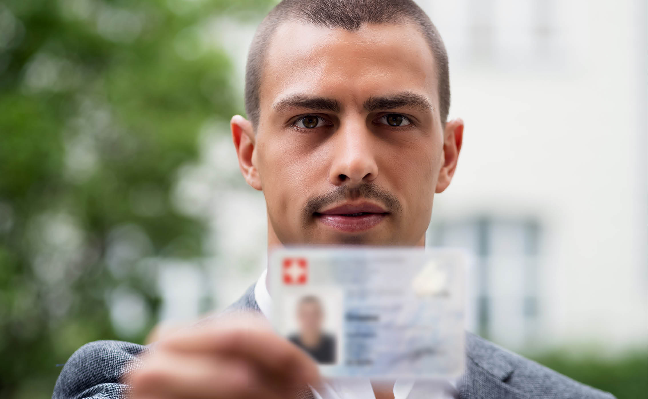 young_man_holding_a_swiss_id_card_into_the_camera