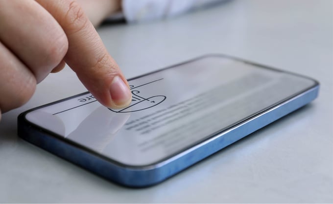 Person signing document on a smartphone