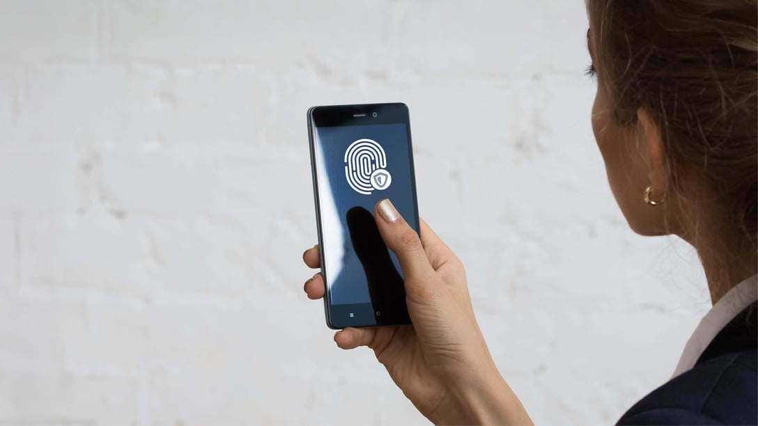 A woman looking at a smartphone with an ID app