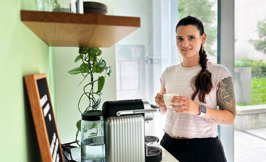 Maya having a cup of coffee at the coffee machine