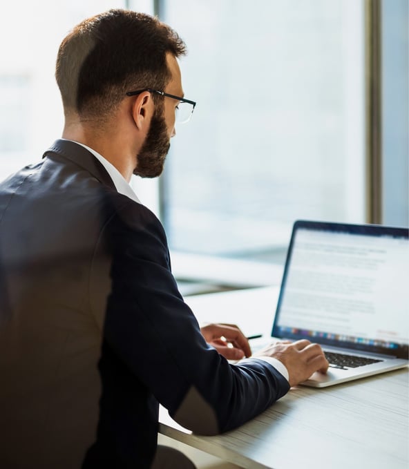 Man working on laptop seen from behind 