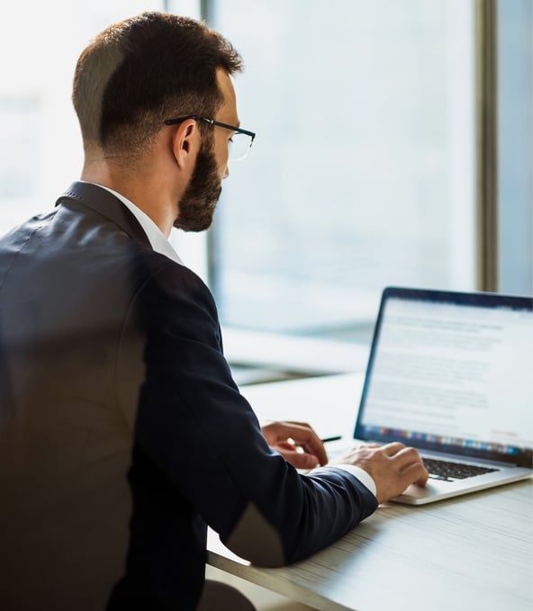 Mann arbeitet an Laptop von hinten gesehen 