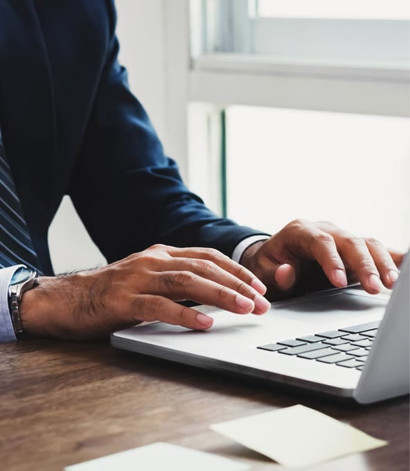 Mann tippt auf Laptop-Tastatur 