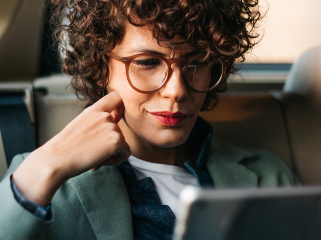 Nahaufnahme einer Frau, die auf einen Laptop-Bildschirm schaut 