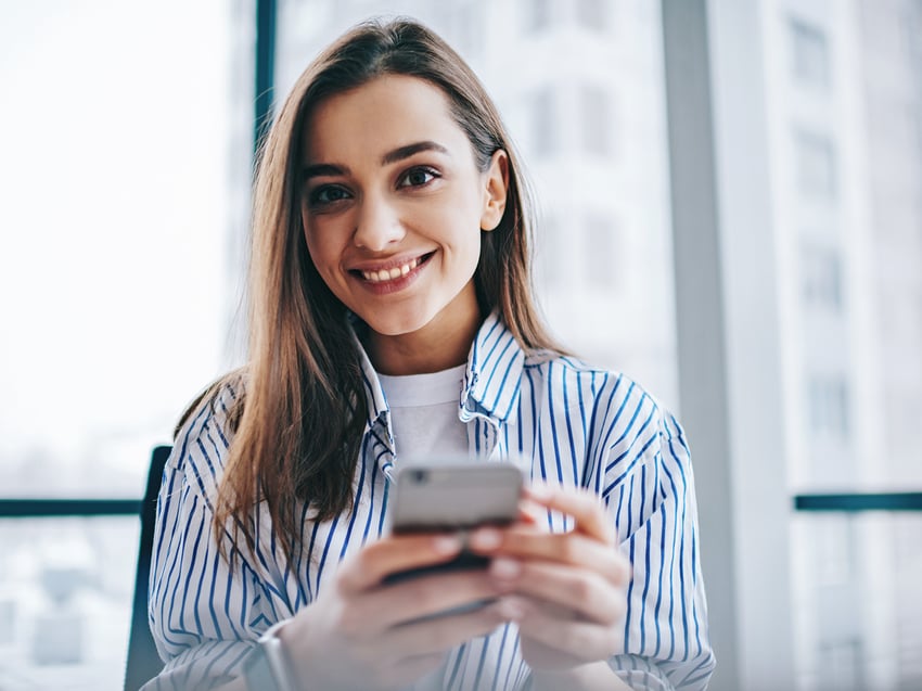 Woman smiling holding a smartphone 
