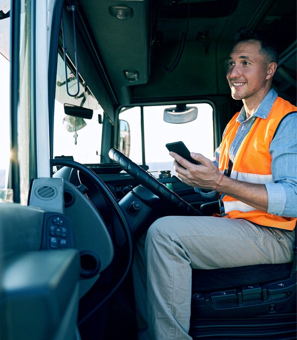 Truck driver wearing orange vest holding smartphone 