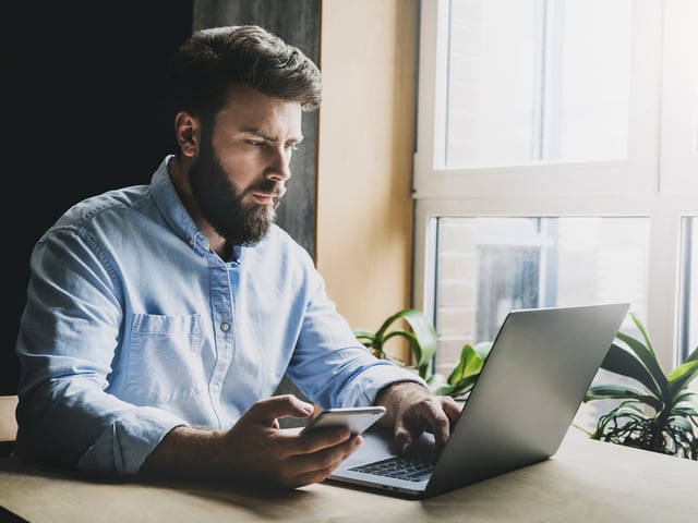 Mann arbeitet an Laptop 