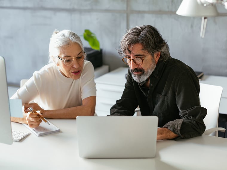 Female working colleague shows something on the computer screen to male colleague