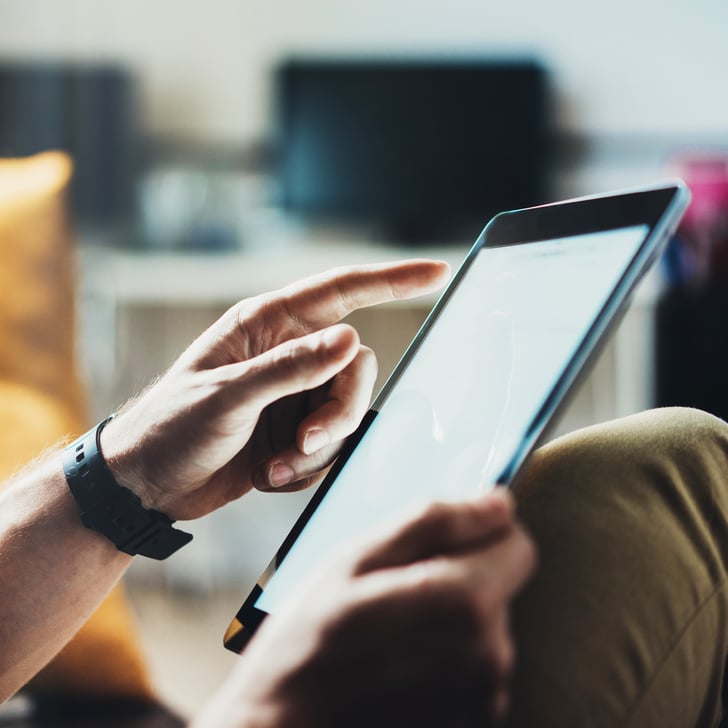 Zwei Hände, die ein Tablet bedienen 