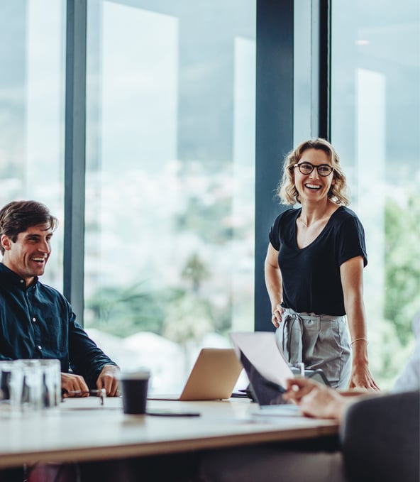 Three working colleagues smiling in meeting room  