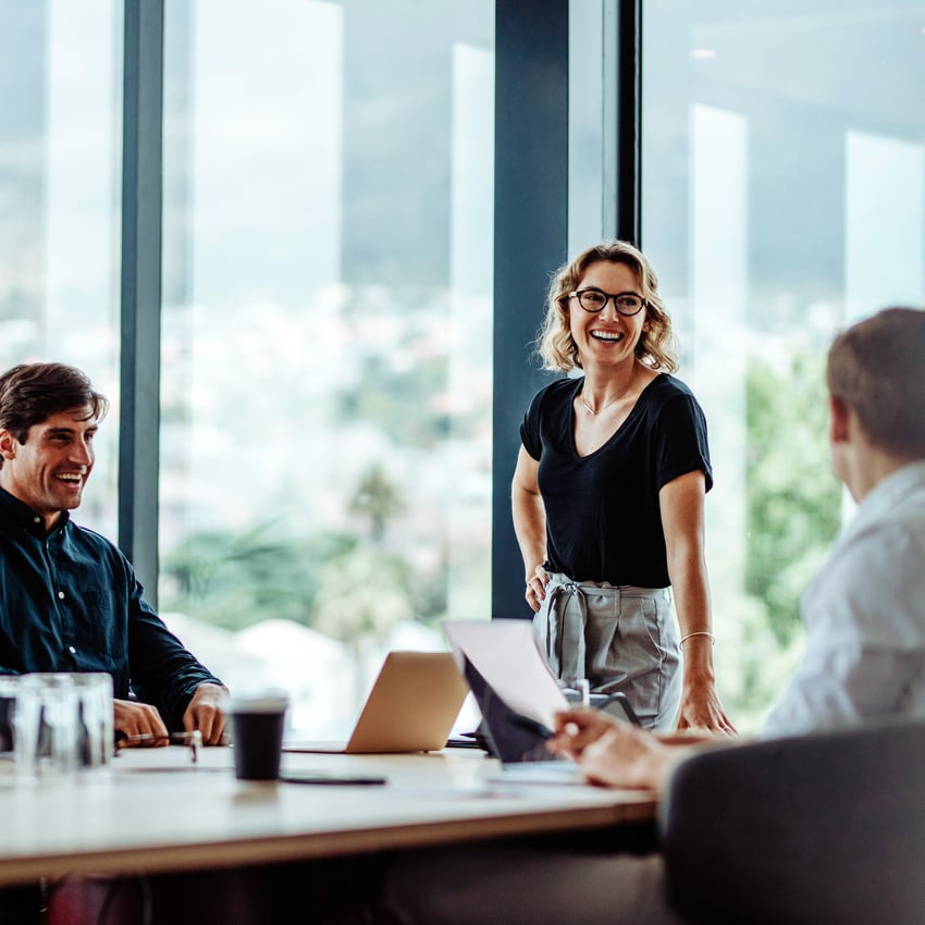 Three working colleagues smiling in meeting room  