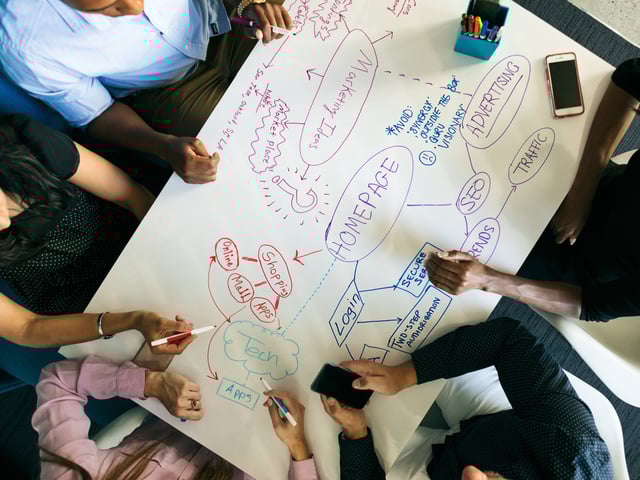 Hands of person holding smartphone and writing on whiteboard 