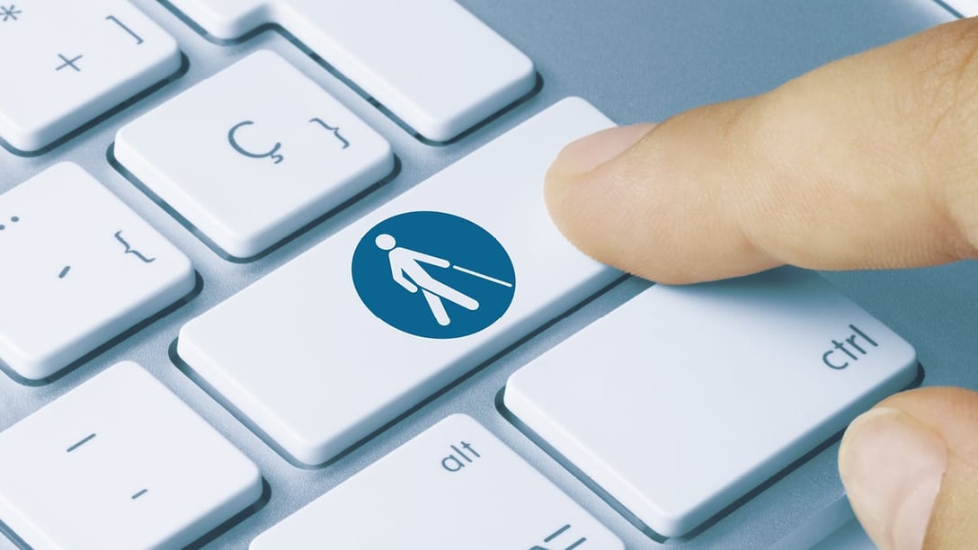 Finger drückt Taste mit Symbol von Person mit Blindenstock auf Keyboard 