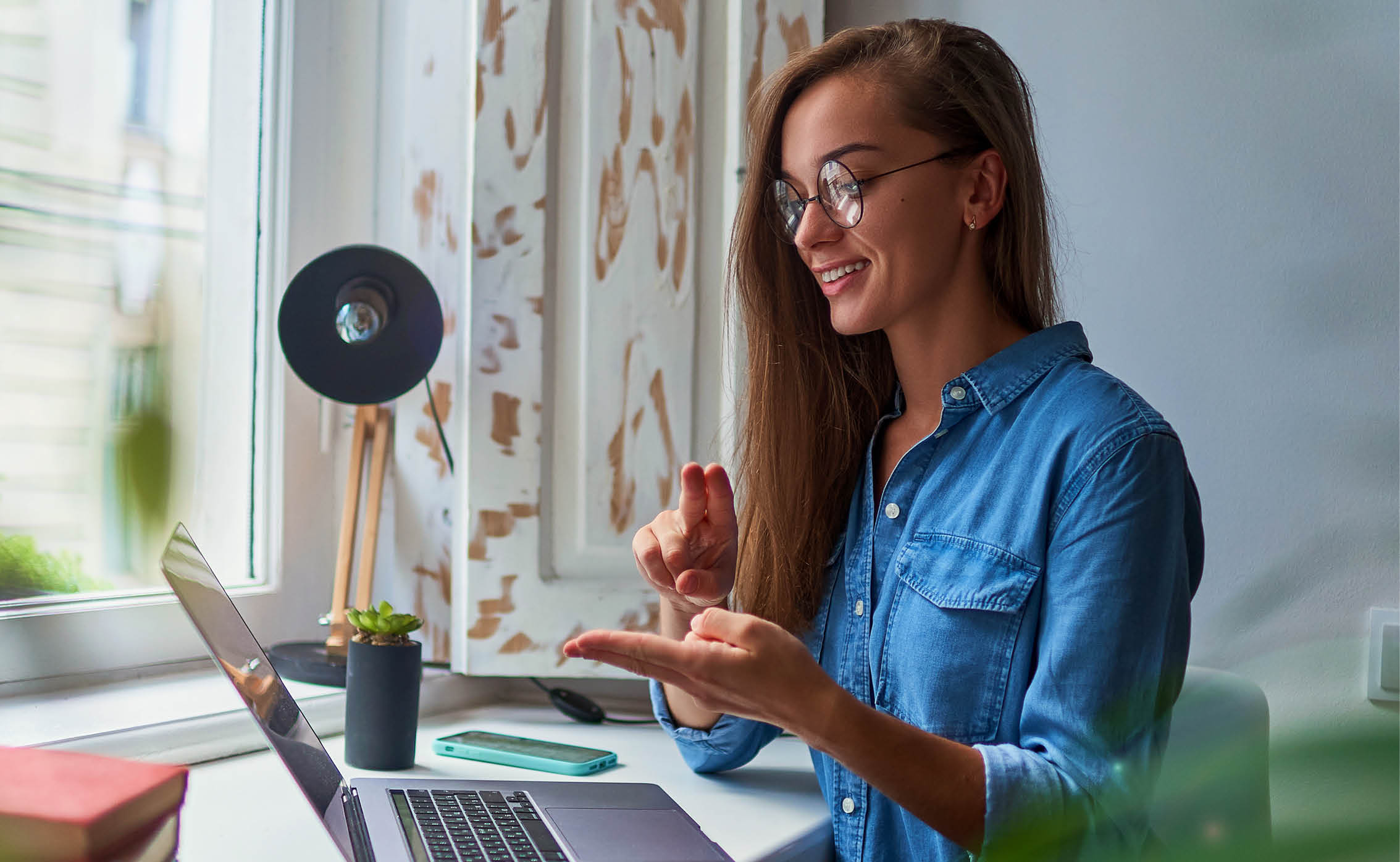 woman looking at laptop and communicating with sign language