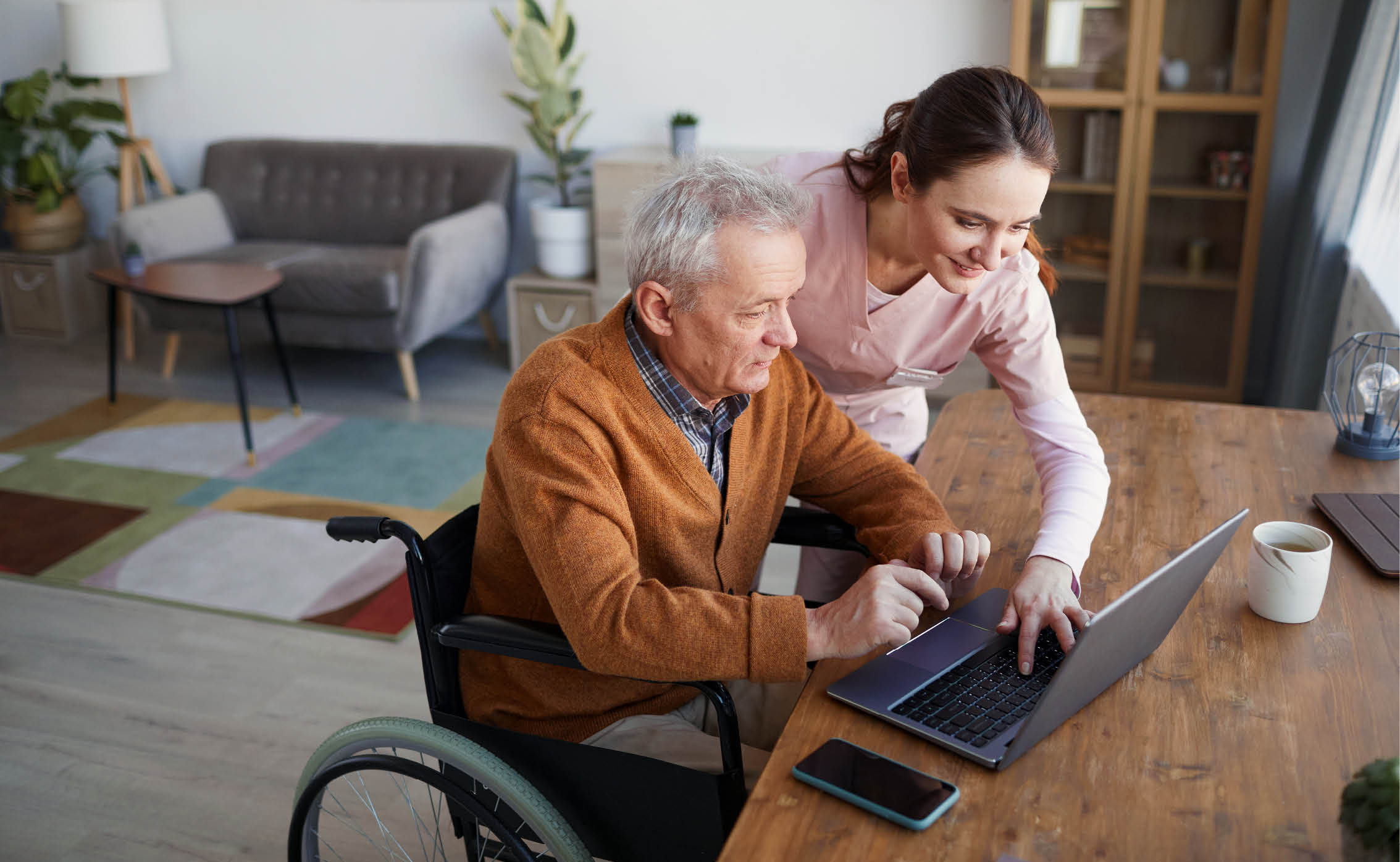 elderly person being assisted in using a laptop