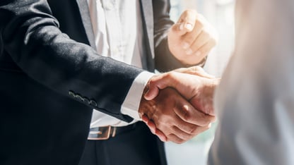 Man in business suit shaking hands with someone 
