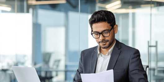 Businessman working by the desk and reading documents.