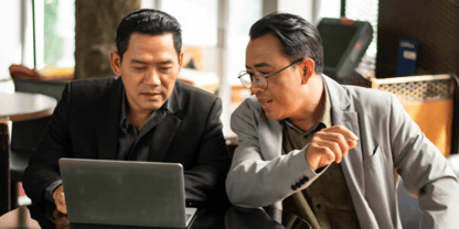 Two businessmen in discussion over a laptop
