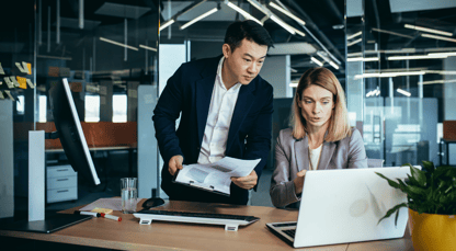 Two business people are looking at a laptop screen and having a discussion
