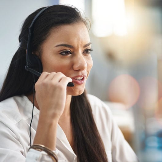 A woman in a call center providing customer support through a headset